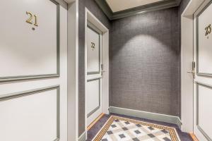 a hallway with doors and a checkered floor at Edgar Suites Expo Paris Porte de Versailles in Paris