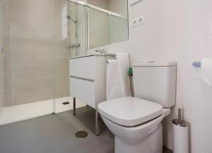 a white bathroom with a toilet and a shower at Camping Villasol in Benidorm