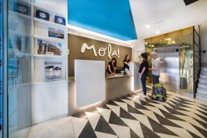 a group of people standing in a restaurant with a counter at Mola Suites in Madrid