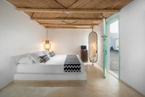 - une chambre avec un lit blanc et un plafond en bois dans l'établissement Sophia Boutique Hotel, à Oia