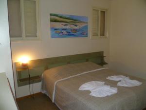 1 dormitorio con 1 cama con toallas en Morada do Girassol, en Florianópolis