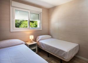 two beds in a small room with a window at Camping Villasol in Benidorm