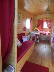 une chambre avec un canapé rouge dans une cabane en bois dans l'établissement La Canfouine, à Lamballe