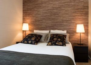a bedroom with a large bed with two lamps at Camping Villasol in Benidorm