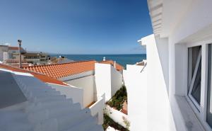 a view of the ocean from a white building at Casa das Aguarelas in Ericeira