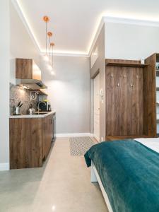 a bedroom with a bed and a kitchen at Apartamenty Wrona | Wrona Apartments in Krakow