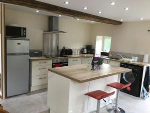 a kitchen with a counter with red stools in it at La Forge in Couesmes-vauce
