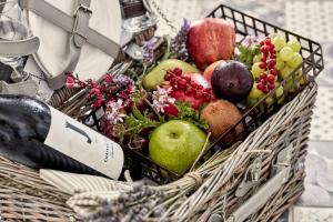 a basket of fruit and vegetables with a bottle of wine at Archipelagos Hotel - Small Luxury Hotels of the World in Kalo Livadi