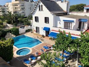 a villa with a swimming pool in front of a building at Hotel Capri in Sitges