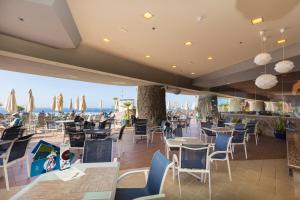 a restaurant with tables and chairs and umbrellas at Gloria Palace Royal Hotel & Spa in Puerto Rico de Gran Canaria