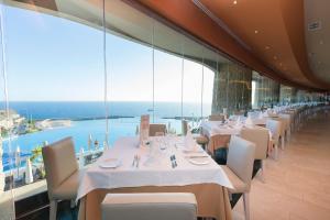 a restaurant with tables and chairs with a view of the ocean at Gloria Palace Royal Hotel & Spa in Puerto Rico de Gran Canaria