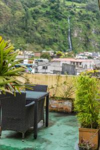 a table and chairs on a balcony with plants at Mayra's Apartments and Spanish School in Baños