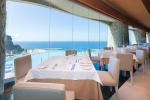 a restaurant with tables and chairs with a view of the ocean at Gloria Palace Royal Hotel & Spa in Puerto Rico de Gran Canaria