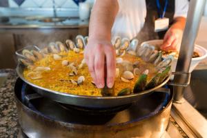 a person is preparing food in a pan at Gloria Palace Royal Hotel & Spa in Puerto Rico de Gran Canaria