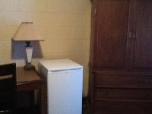 a kitchen with a white refrigerator and a lamp on a desk at Motel Du Parc Masson in Gatineau