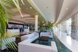 a lobby of a hotel with white furniture and plants at Gloria Palace Royal Hotel & Spa in Puerto Rico de Gran Canaria