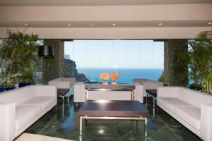 a restaurant with white furniture and a view of the ocean at Gloria Palace Royal Hotel & Spa in Puerto Rico de Gran Canaria