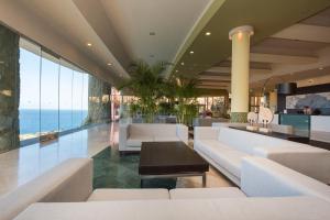 a lobby with white furniture and a view of the ocean at Gloria Palace Royal Hotel & Spa in Puerto Rico de Gran Canaria
