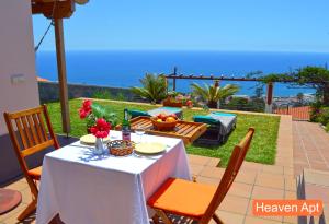 un patio avec une table et des chaises et l'océan dans l'établissement Villa Henriques, à Funchal