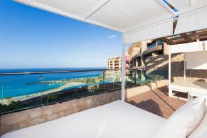 a bedroom with a balcony with a view of the ocean at Gloria Palace Royal Hotel & Spa in Puerto Rico de Gran Canaria