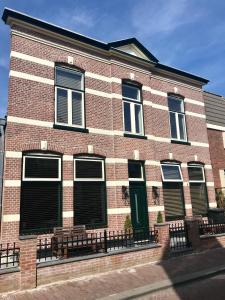 a red brick building with black shutters on it at Loft Studio's in Zandvoort