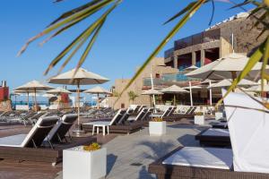 a row of lounge chairs and umbrellas at a resort at Gloria Palace Royal Hotel & Spa in Puerto Rico de Gran Canaria