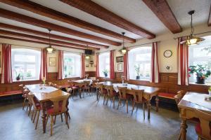 ディンケルスビュールにあるGasthof Goldenes Rössleの木製のテーブルと椅子、窓のあるレストラン