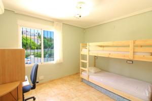 カルプにあるCanuta de Ifach 17Jの二段ベッド2台と窓が備わる客室です。