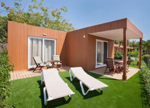 a patio with two chairs and a table on a lawn at Camping Villasol in Benidorm