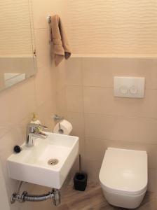a bathroom with a white sink and a toilet at Apartmani Marin in Vrbnik