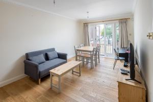 a living room with a couch and a tv and a table at Smart 2 bedroom flat in Southwark, minutes from Waterloo tube! in London