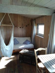 Bett in einem Zimmer mit Hängematte in der Unterkunft La cabane en bois in Villemur-sur-Tarn