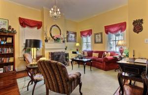 a living room with a red couch and a fireplace at Green Palm Inn in Savannah