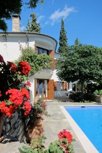 una casa con piscina y flores rojas en Villa Sommer, en Portaria