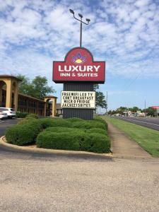 a sign for a luxury inn and suites on a street at Luxury Inn & Suites in Selma