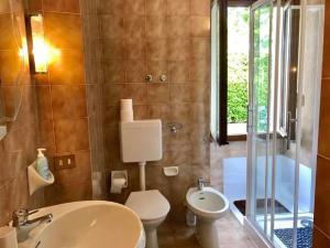 a bathroom with a sink and a toilet and a tub at Le Betulle in Oggebbio