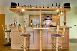 a man standing at a bar in a restaurant at Hotel Heidler in Niederau