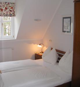 a bed with white sheets and pillows in a room at Winzerhaus Friedrich in Kaindorf