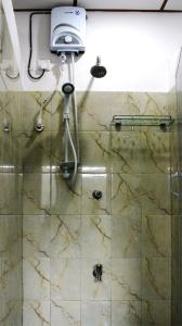 a bathroom with a shower with a glass door at Hiranya Mountain View Hostel Kandy in Kandy