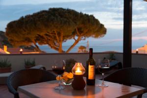 a table with two wine glasses and a bottle of wine at Hotel Corallo in Pomonte