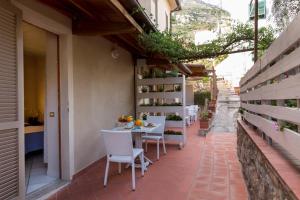 eine Terrasse mit einem Tisch und Stühlen auf einem Gebäude in der Unterkunft Hotel Corallo in Pomonte