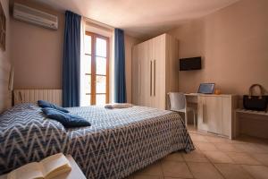 a bedroom with a bed with blue pillows on it at Hotel Corallo in Pomonte