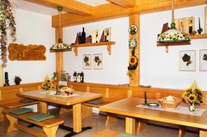 due tavoli e sedie in un ristorante con girasoli di Weingut Sommerhof a Mörbisch am See