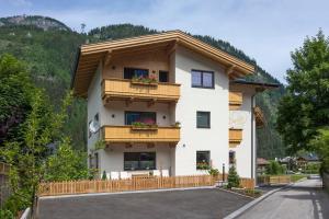 a house in the mountains with flowers on the balconies at Apart Dengg in Mayrhofen