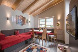 a living room with a red couch and a table at Apart Dengg in Mayrhofen