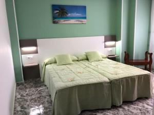ビジャロンガにあるPension Casa Prietoの緑の壁のベッドルーム1室(大型ベッド1台付)