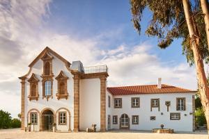 um grande edifcio branco com um telhado vermelho em Convento do Seixo Boutique Hotel & Spa no Fundo