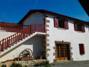 a white house with a red staircase and a window at Maison Zubiatia - 3km Compostelle in Saint-Jean-le-Vieux