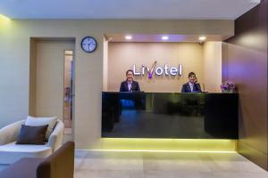 two men standing at a desk in a lobby at Livotel Hotel Kaset Nawamin Bangkok in Bangkok