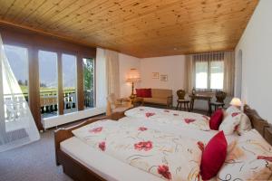 a bedroom with two beds and a balcony at Hotel Arvenbüel in Amden